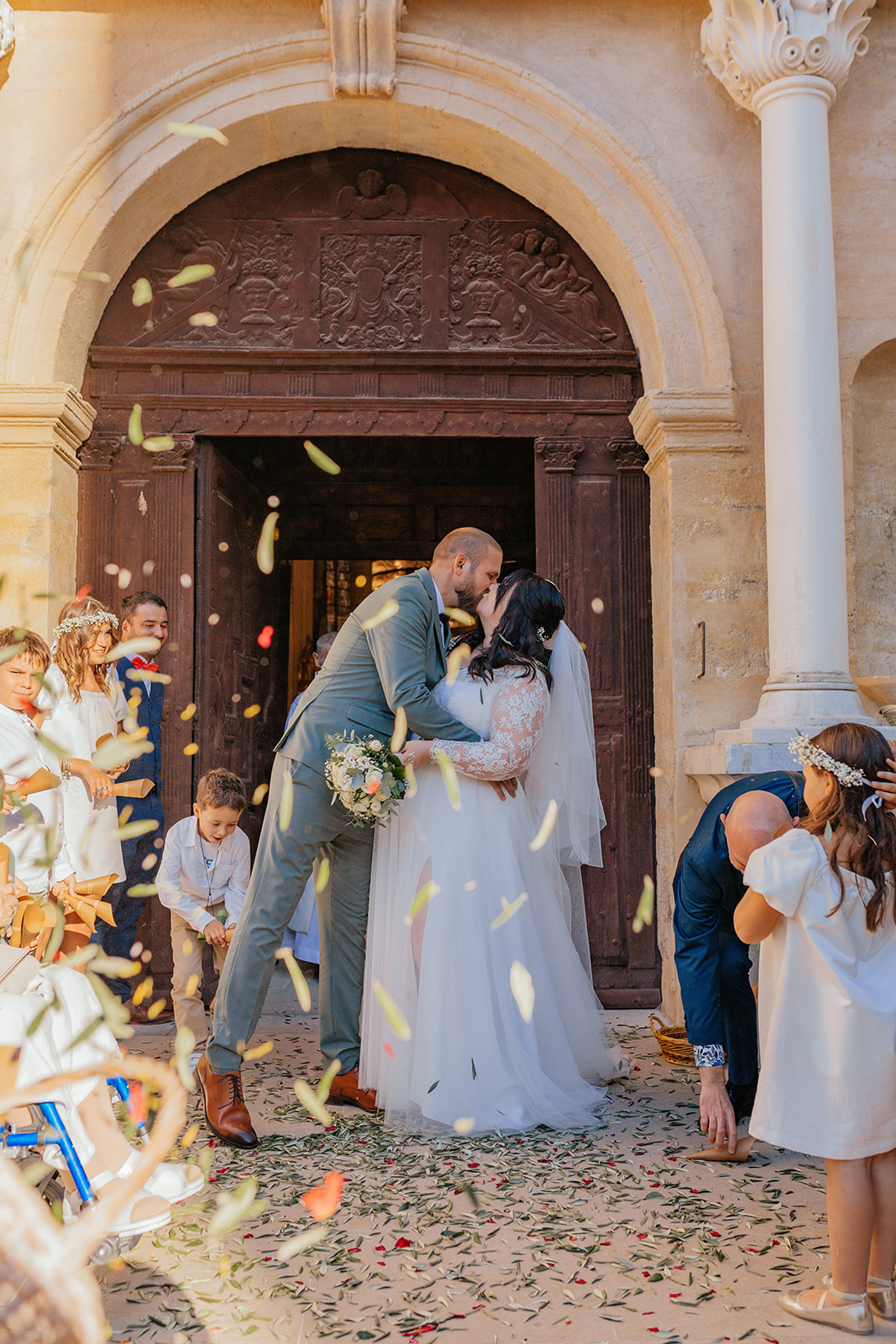 Les mariés sortent de l’église sous une pluie de confettis, rayonnants de joie.
